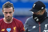 Liverpool player Jordan Henderson walks with manager Jurgen Klopp, wearing a mask, after a Premier League clash with Everton.