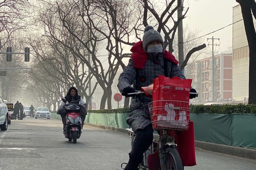 Women ride on motorcycles wearing face masks.