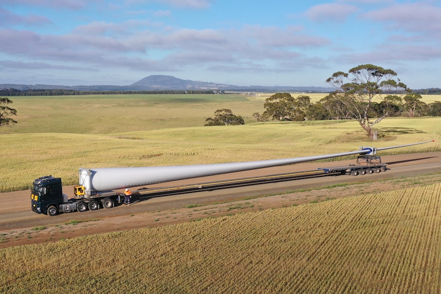 Aerial view of a wind turbine blade being transported on a truck.