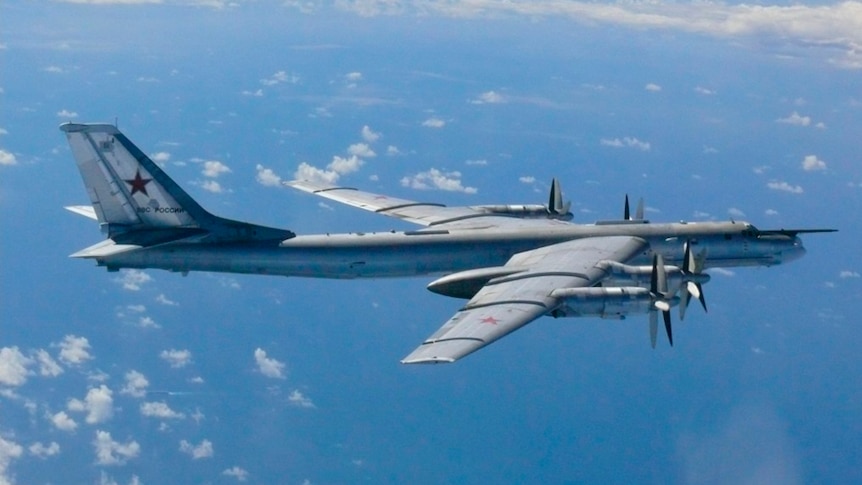 A Russian TU-95 bomber flying over the ocean.