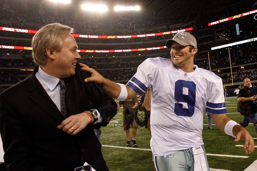 Dallas Cowboys quarterback Tony Romo (right) puts his hand on the shoulder of a team executive after an NFL game.