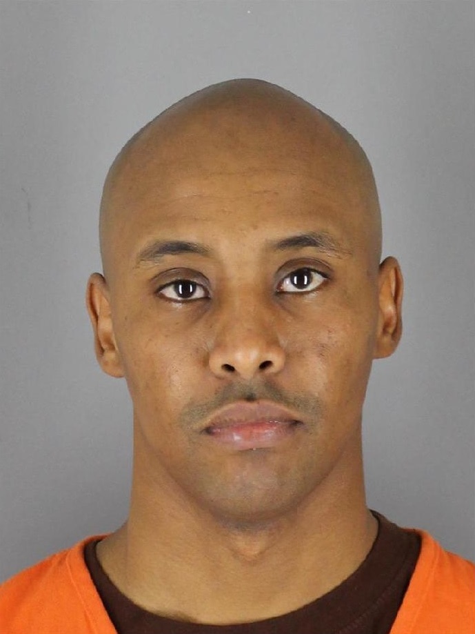 A head and shoulders shot of Mohamed Noor who has an orange top on.