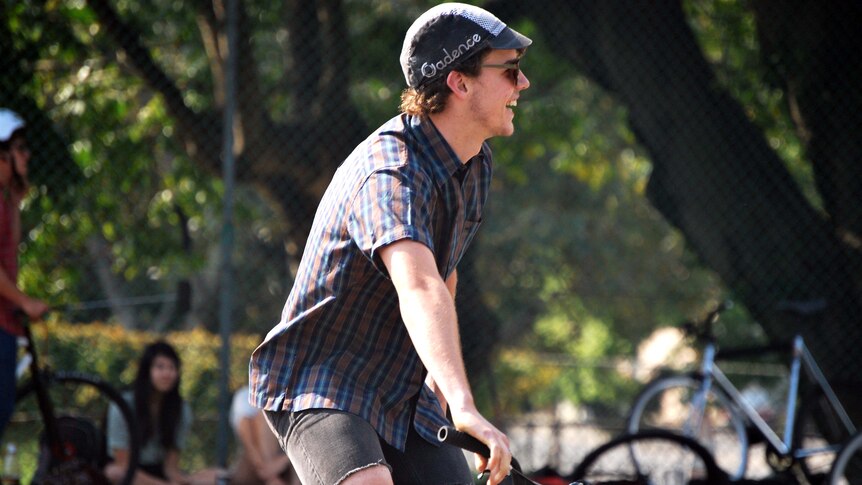 Young bike polo player laughs during match