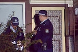 Police attend the scene of a double murder at a house in Windeyer Street, Mayfield