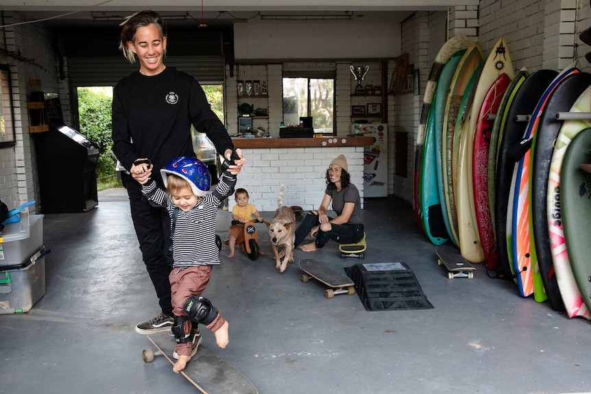 Amee and Milenka playing with their two children in a garage.