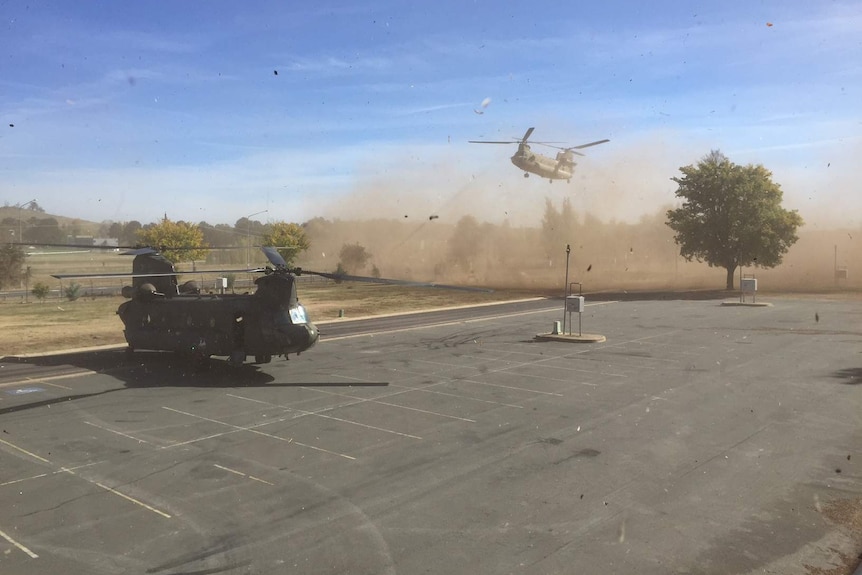 Two Chinook Helicopters kick up plenty of dust as they land in Canberra