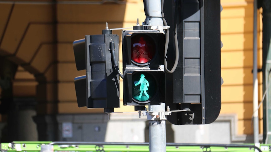 A pedestrian crossing light flashes with a female silhouette.