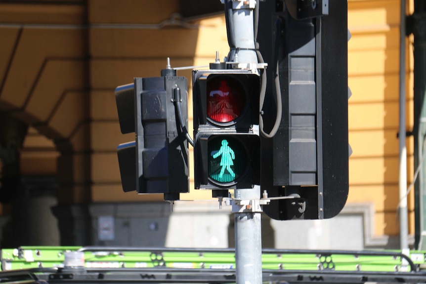 A pedestrian crossing light flashes with a female silhouette.