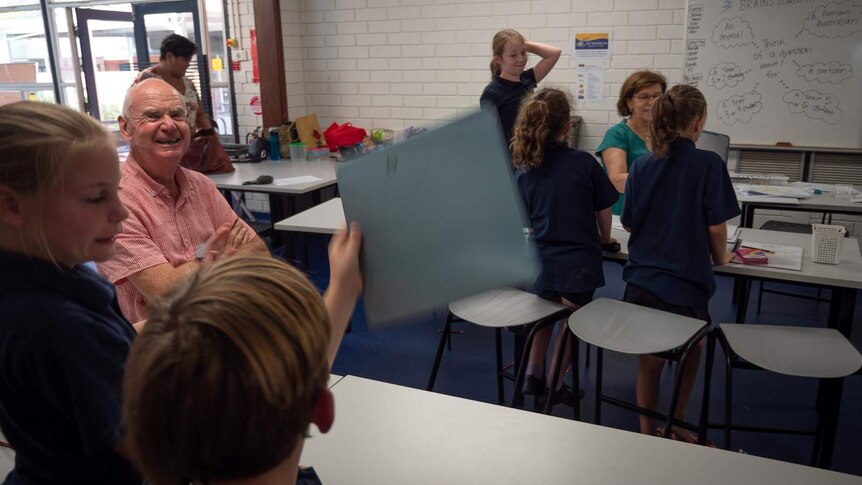 Kids hold up their answer boards at learning club.