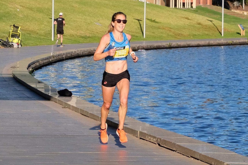 A woman running along a river boardwalk