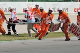 Medical staff carry Shoya Tomizawa from the track on a stretcher. He later died in hospital