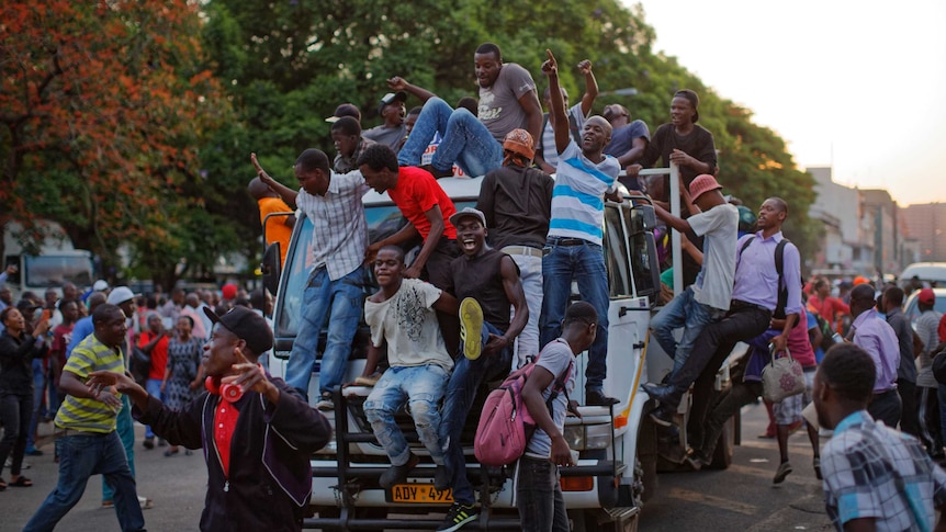 Zimbabweans hang off cars and fill the streets to celebrate Robert Mugabe's resignation.