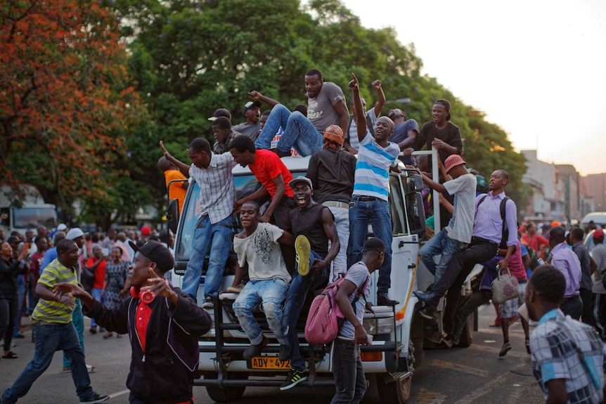 Zimbabweans hang off cars and fill the streets to celebrate Robert Mugabe's resignation.
