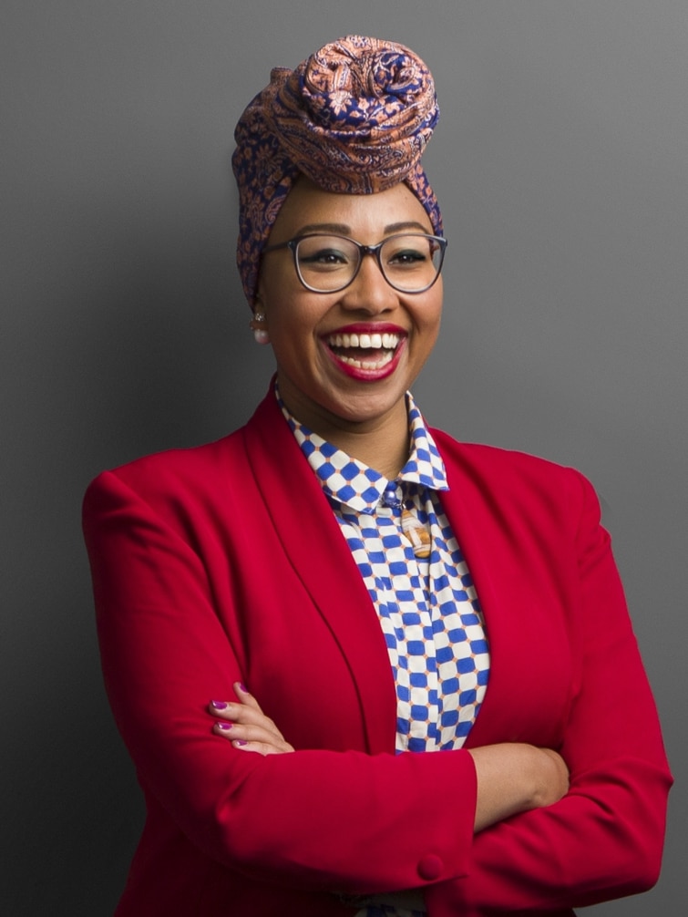 Yassmin Abdel-Magied stands smiling with her arms folded.