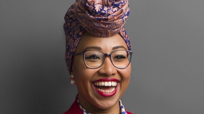Yassmin Abdel-Magied stands smiling with her arms folded.