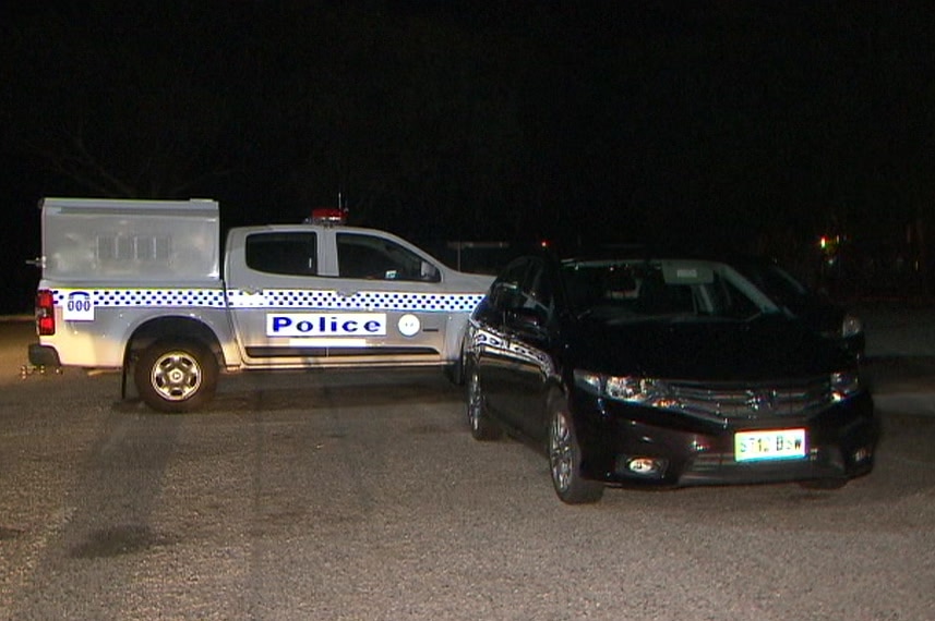 A black small Honda sedan in front with a police four-wheel drive behind