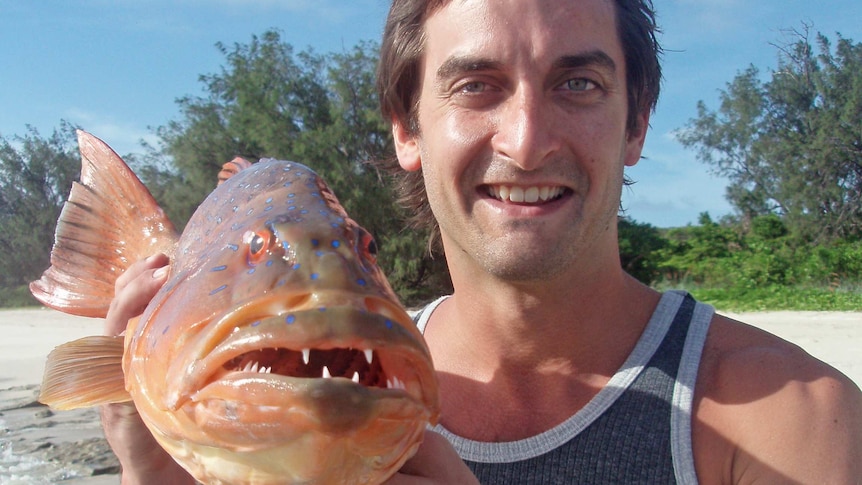 Researcher Timothy Clark holds a coral grouper