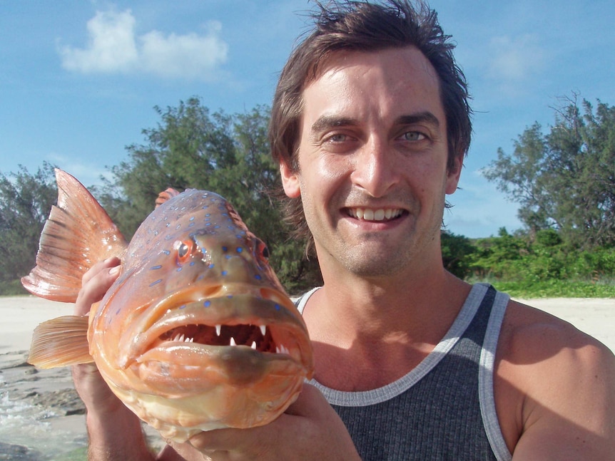 Researcher Timothy Clark holds a coral grouper