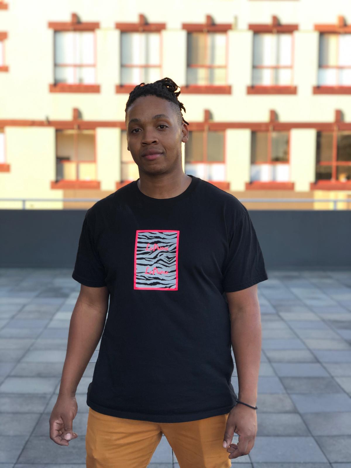 Sammy Benbow wearing one of his designs - a black t-shirt with coloured print