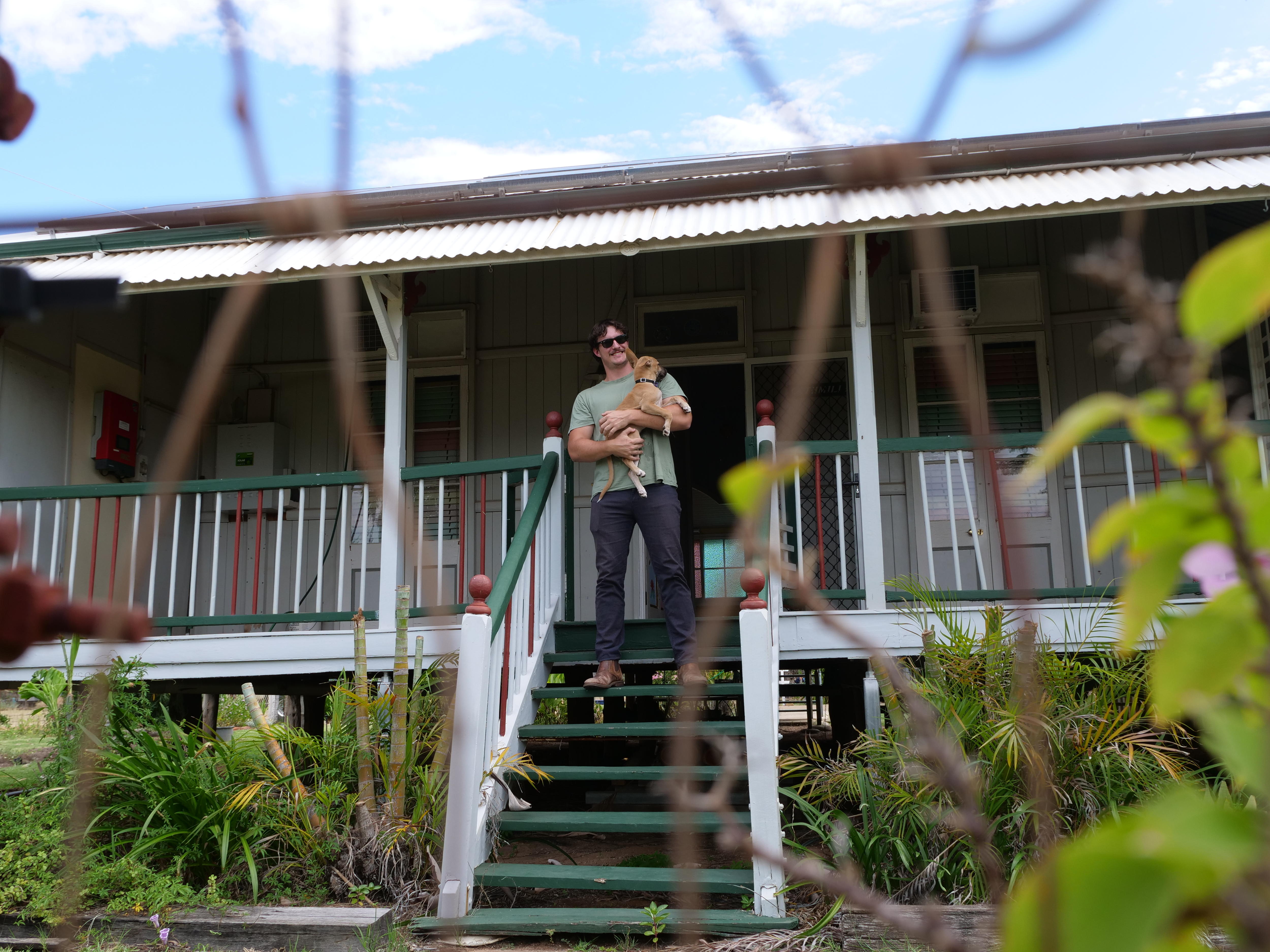 El hombre se encuentra en las escaleras de la Casa Queenslander 