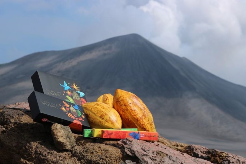"Volcanic" Kit Kats and cocoa plants sit on a rock, with a volcano in the background.