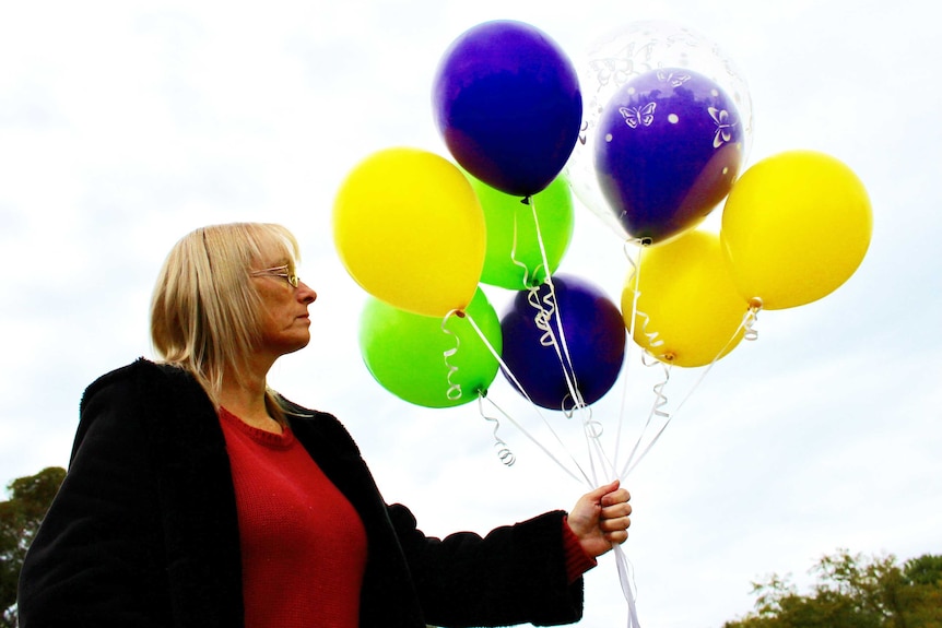 Karren Harrison clutching balloons