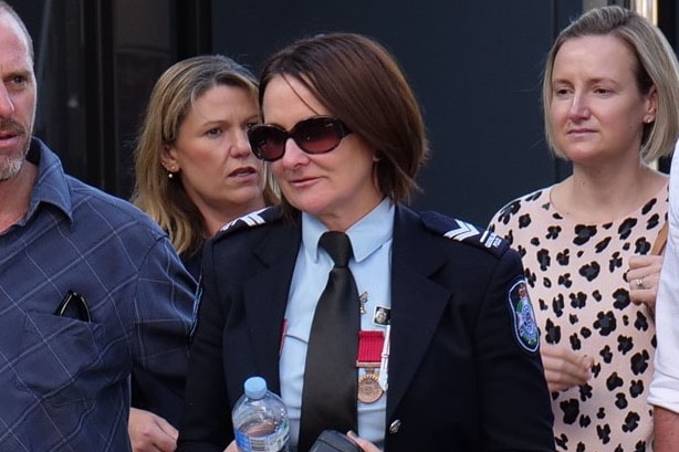 Senior Constable Catherine Nielsen in uniforms leaves court wearing sunglasses.