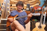 Close-up of Jim Mills with a guitar in his studio