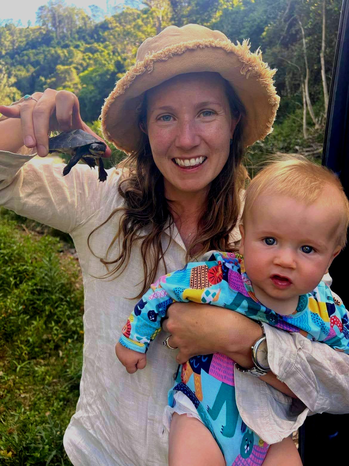 Woman holds an endangered turtle and her five month old baby