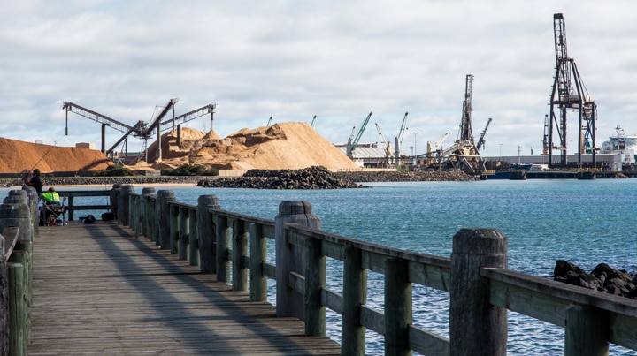 Cranes and woodchip piles at Burnie port