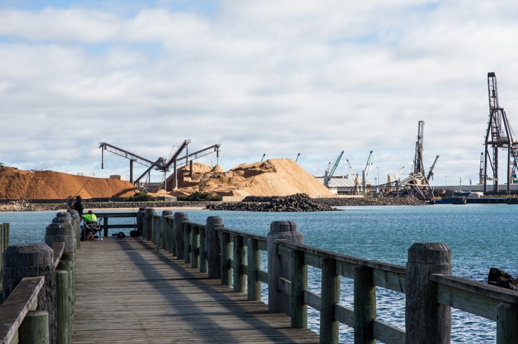 Cranes and woodchip piles at Burnie port