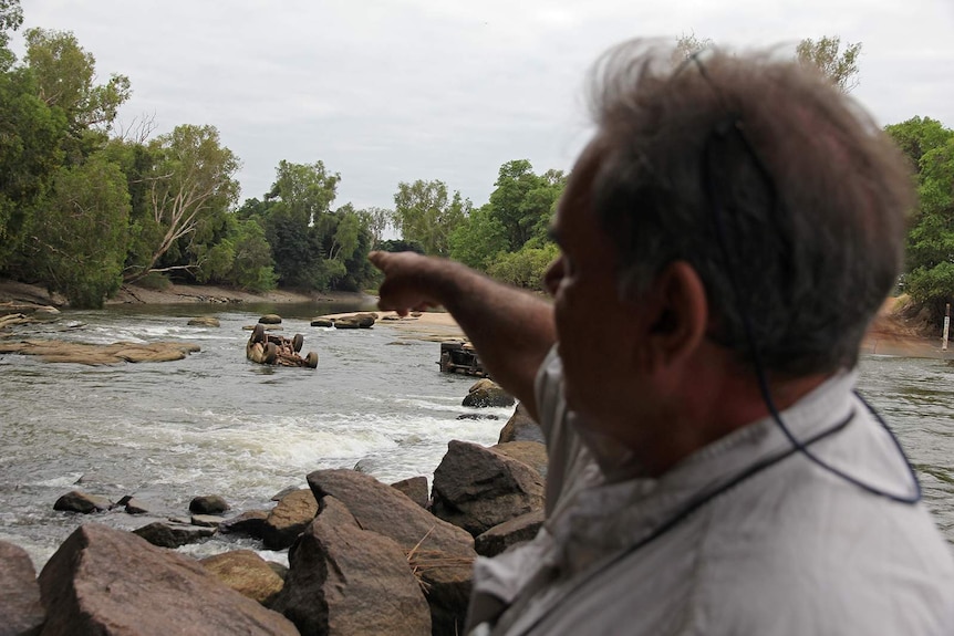 A photo of Gary Lindner pointing out a washed away car at the crossing.