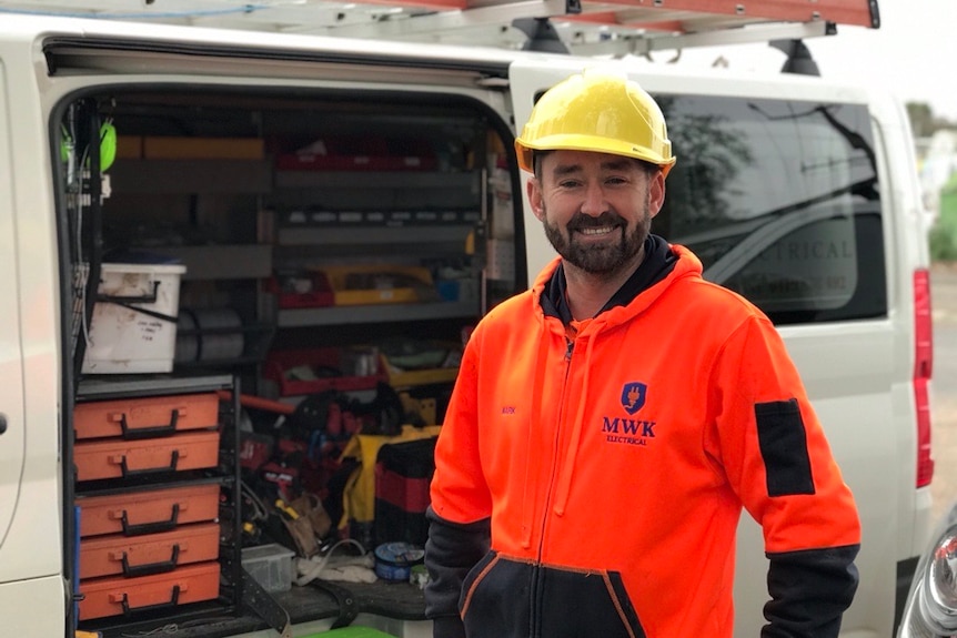 Una foto de un hombre que usa hi vis y un casco amarillo