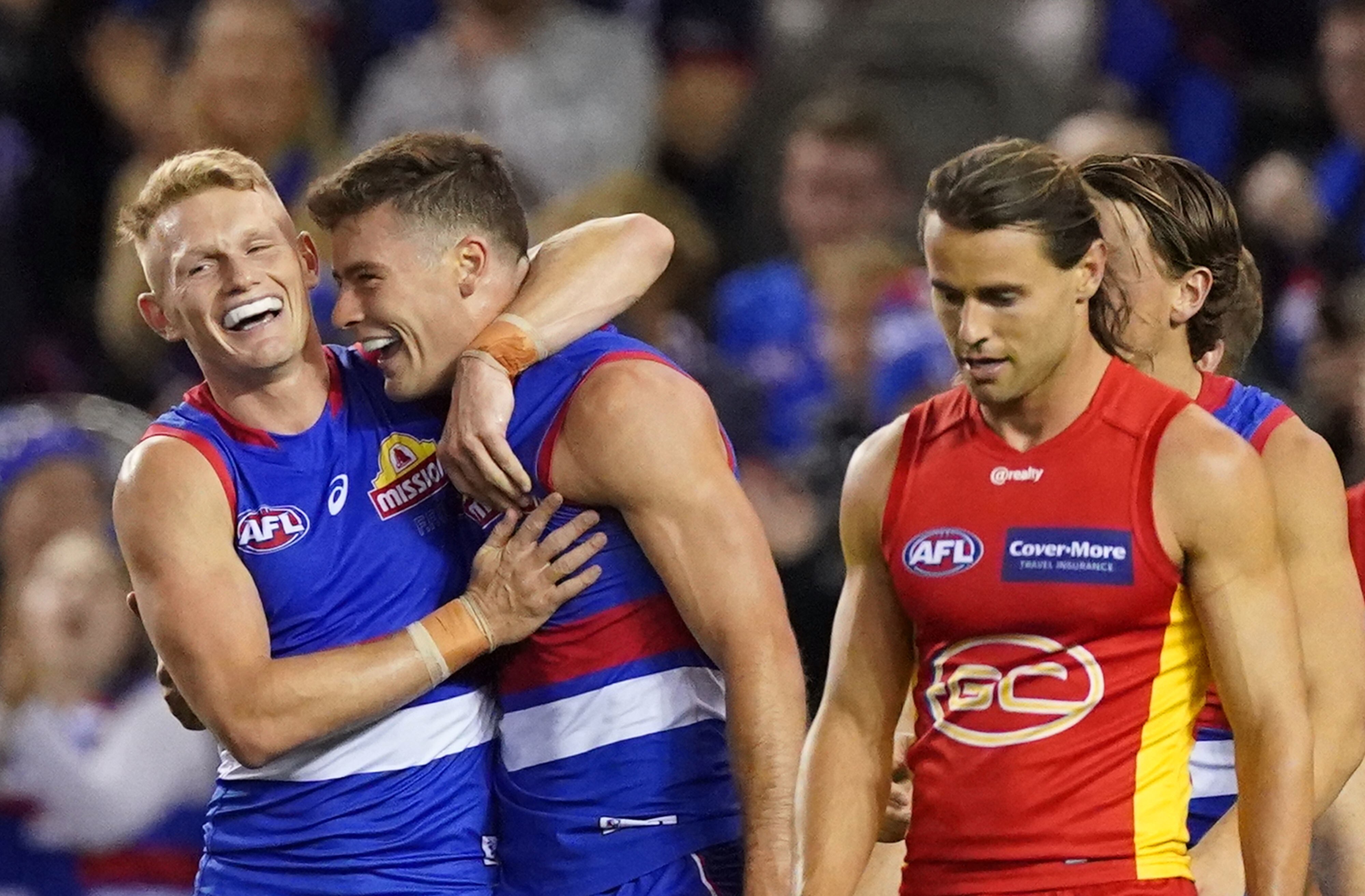Two Western Bulldogs AFL players embrace as they celebrate a goal against Gold Coast.