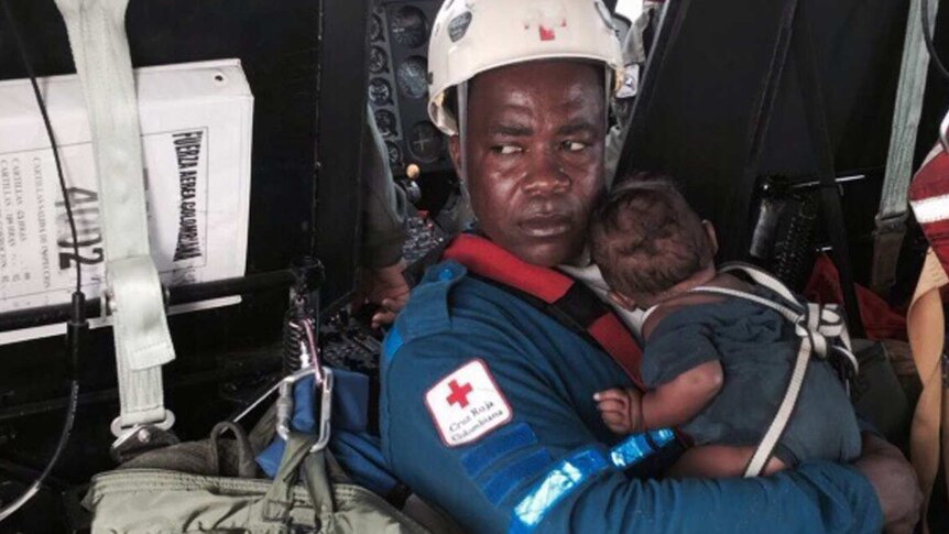 Red Cross member holding baby Yudlier Moreno after his mother and him were found in the Colombian jungle following a plane crash