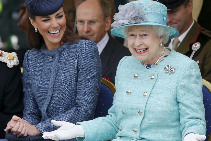 Catherine, Duchess of Cambridge laughs as Queen Elizabeth II gestures.