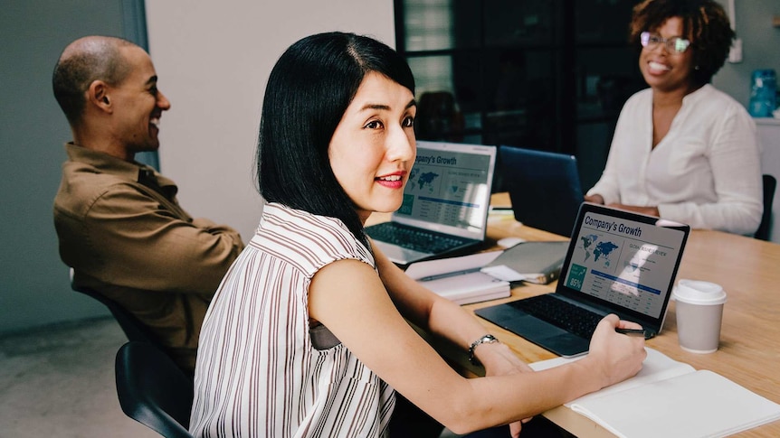 Woman in a work meeting looking up with a slightly displeased expression on her face