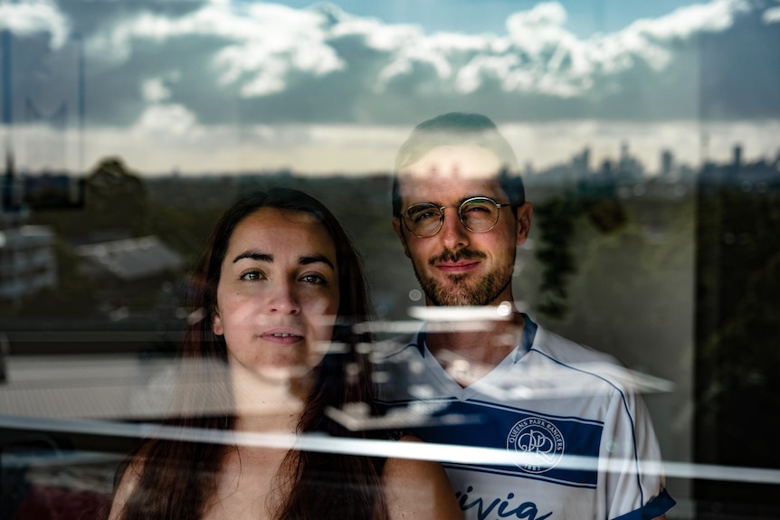 A man and a woman look through a window