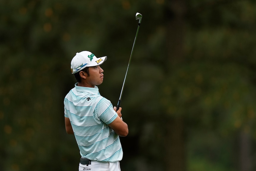 Hideki Matsuyama looks up after completing a shot