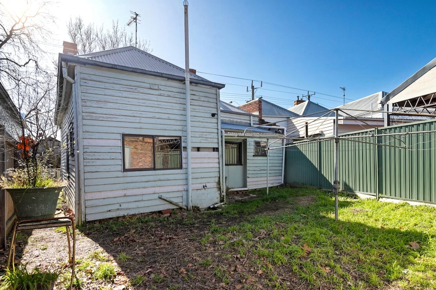 A weatherboard house with a missing board. 