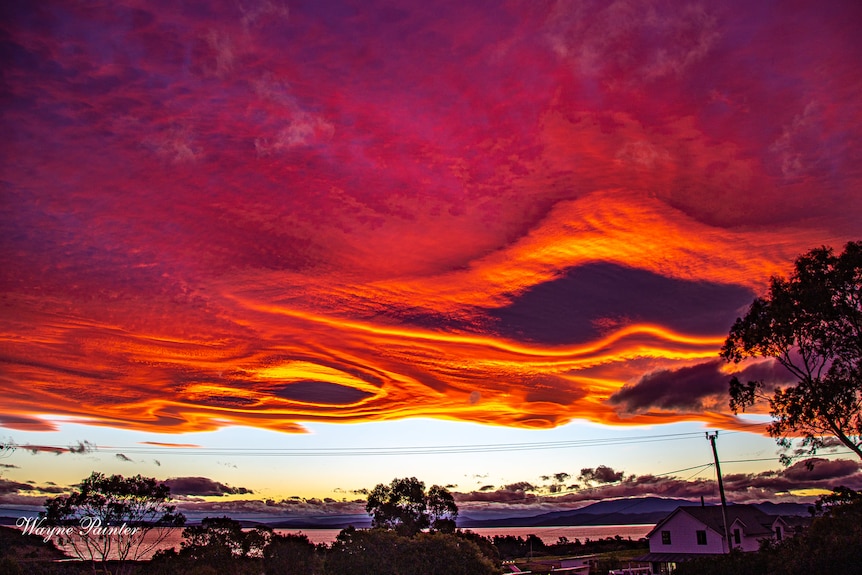 Red and orange swirling clouds seen in the sky at sunset.
