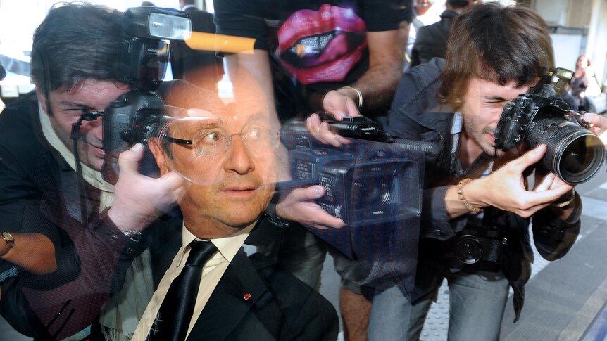 France's President Francois Hollande is photographed through a window of a train.