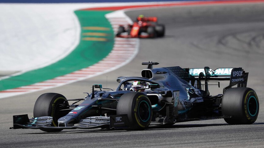 The Mercedes of Lewis Hamilton on the track at the US Grand Prix, with a Ferrari in the background.