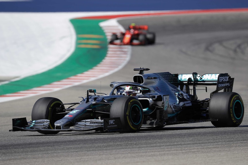 The Mercedes of Lewis Hamilton on the track at the US Grand Prix, with a Ferrari in the background.