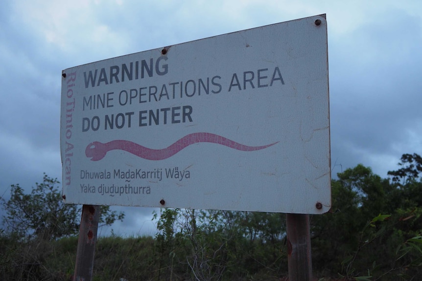 A sign saying "warning mine operations area do not enter".