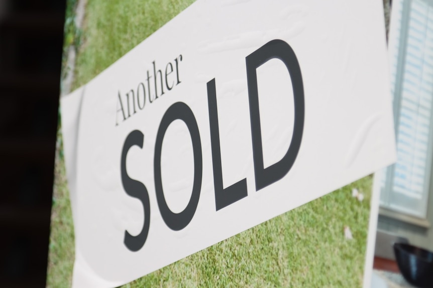 White banner saying "another sold" following house sale.