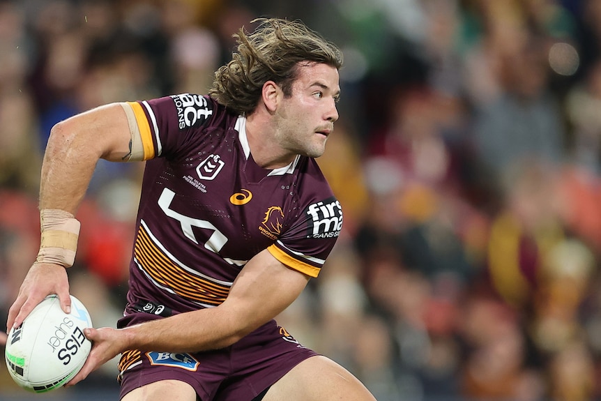 Broncos prop Patrick Carrigan passing the football during a match