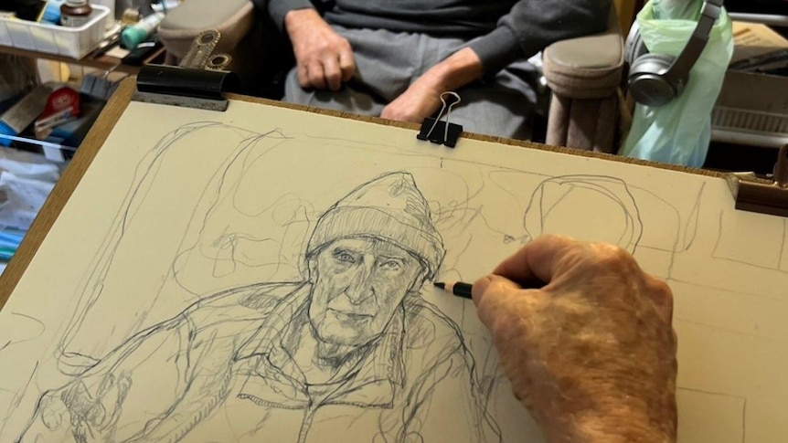 A pencil sketch of an elderly man in a beanie. The subject is sitting in an armchair in the background.