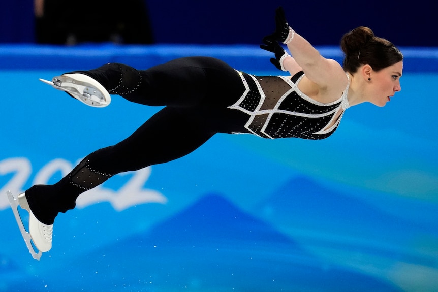 A figure skater flies through the air.