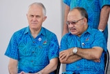 Malcolm Turnbull and Peter O'Neill sit side-by-side wearing the same blue, patterned shirts